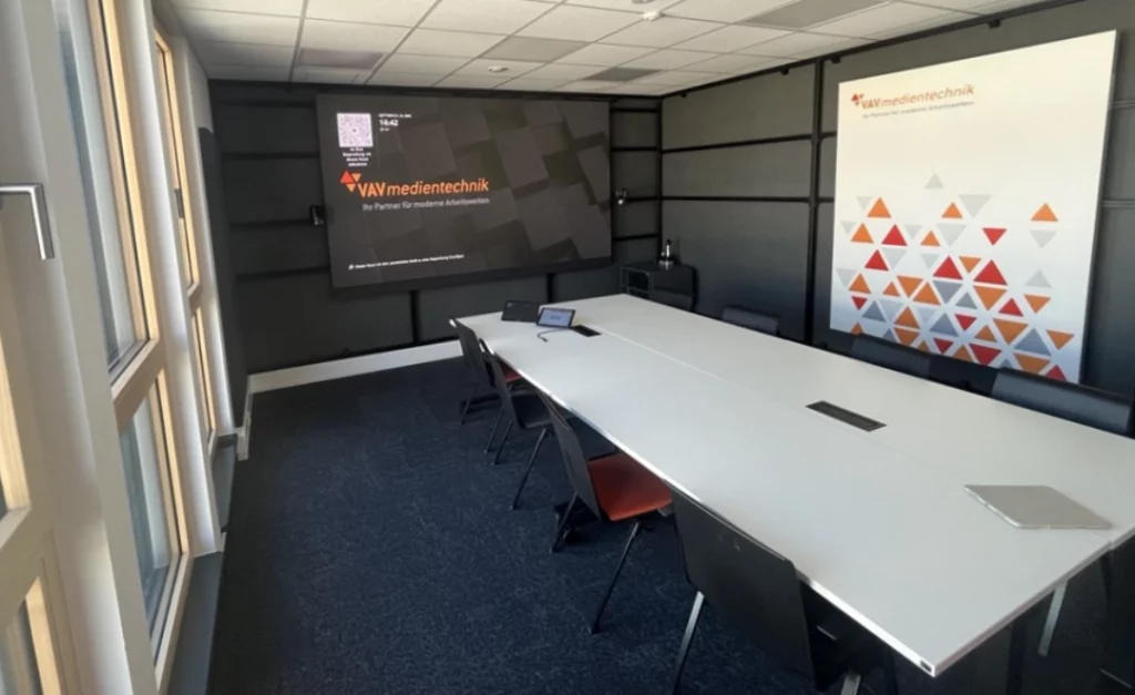 Blick in den Konferenzraum Isar. Ein langer Tisch mit Stühlen, vorn eine große Leinwand.