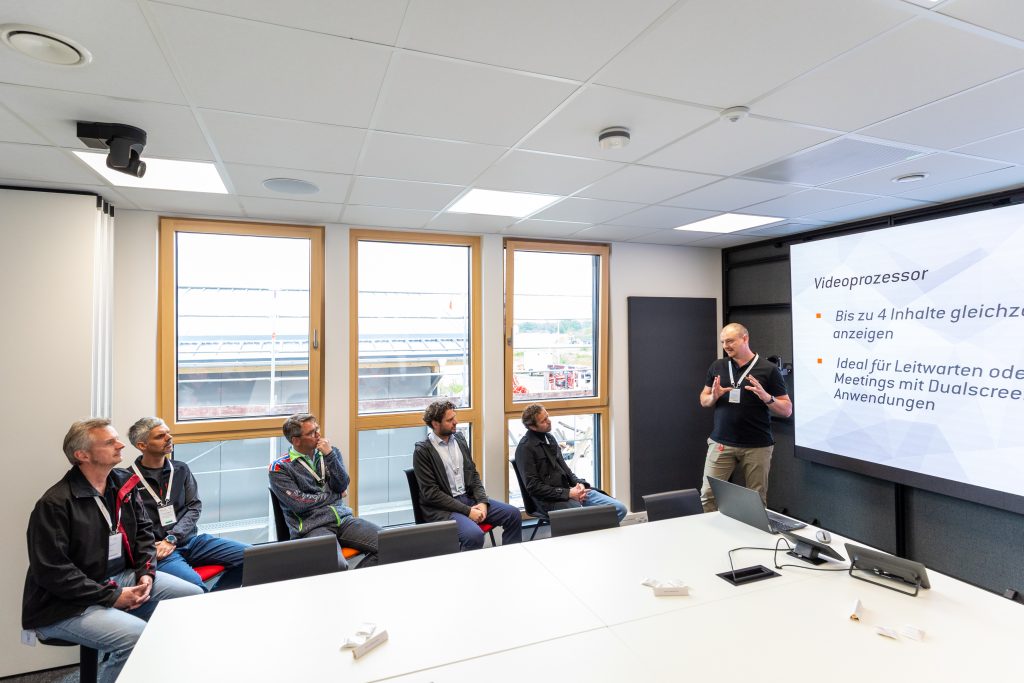 Raum Isar Live‑Demo Besprechung im Raum Isar mit Teilnehmern vor LED‑Wand