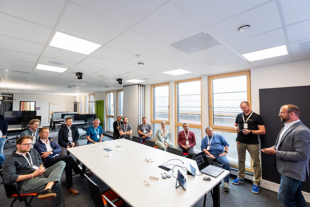 Hybridmeeting vor LED‑Wand mit KI‑Tracking