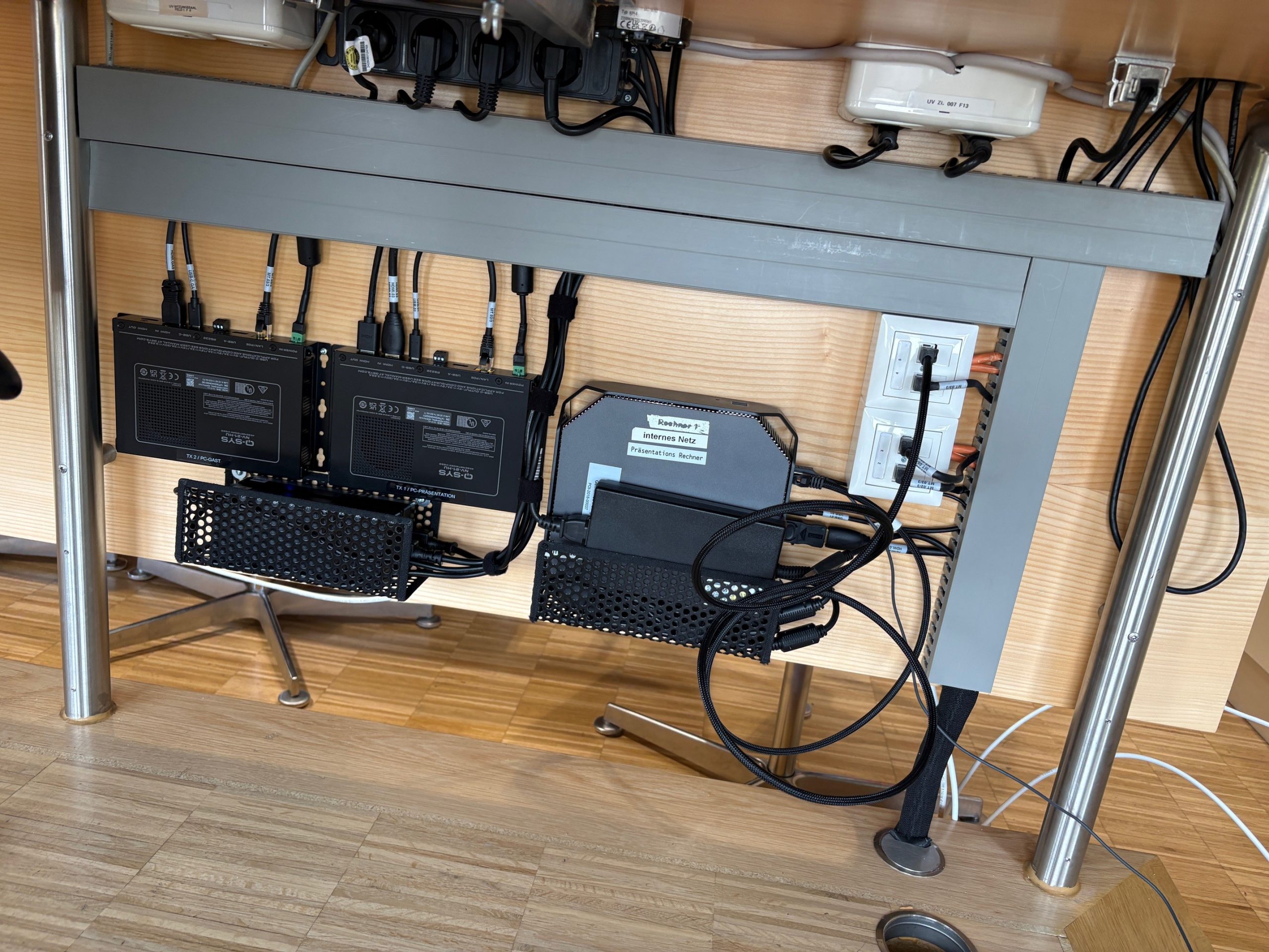 Technikinstallation unter dem Konferenztisch mit Signalwandlern und Netzwerk