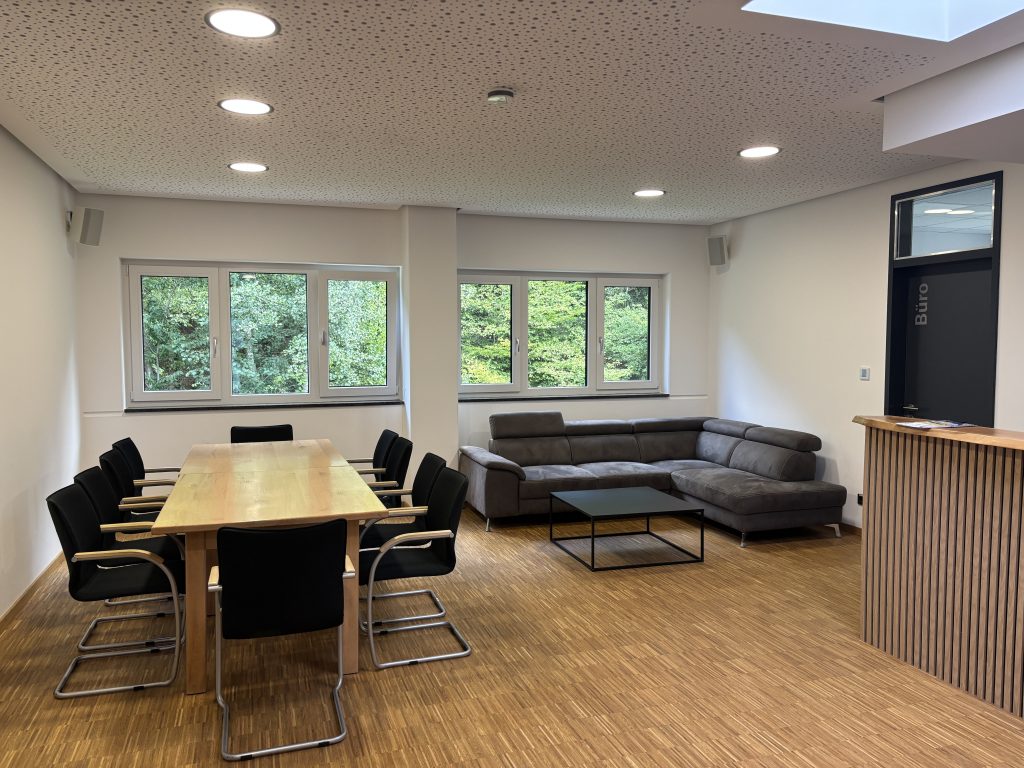 Lounge mit Besprechungstisch, Sofaecke und Fensterfront